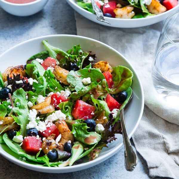 Bol de repas frais avec légumes, céréales et ingrédients colorés sur une table blanche